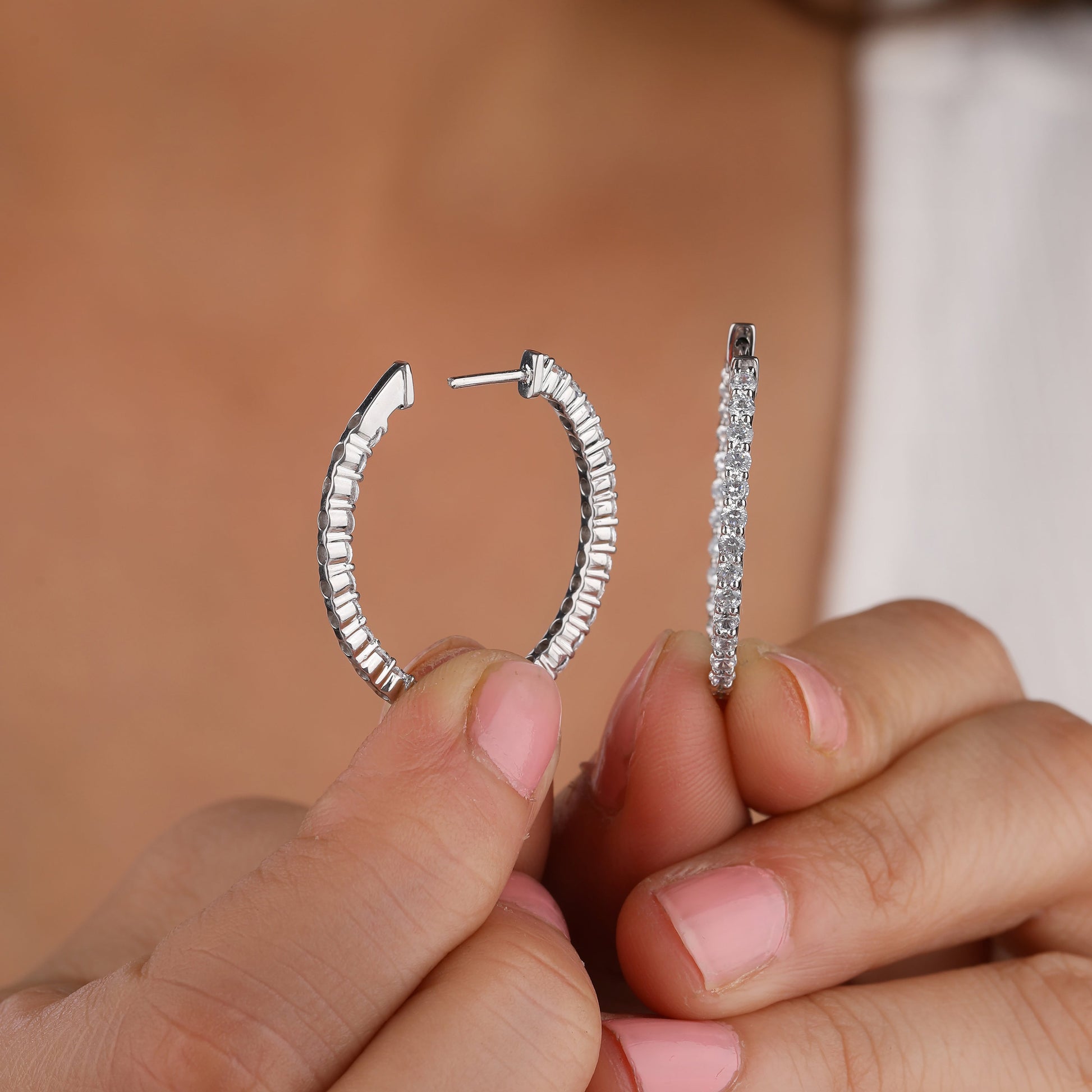 a girl holding hoop earrings