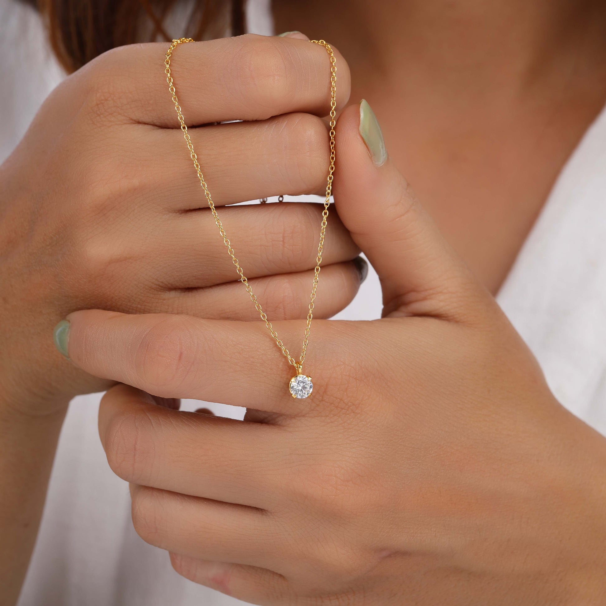 A person holding solitaire necklace