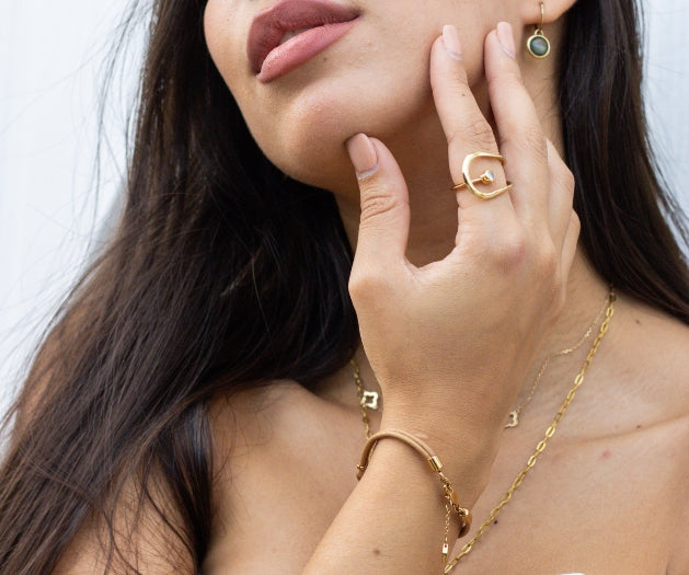 a women wearing minimalist gold jewelry
