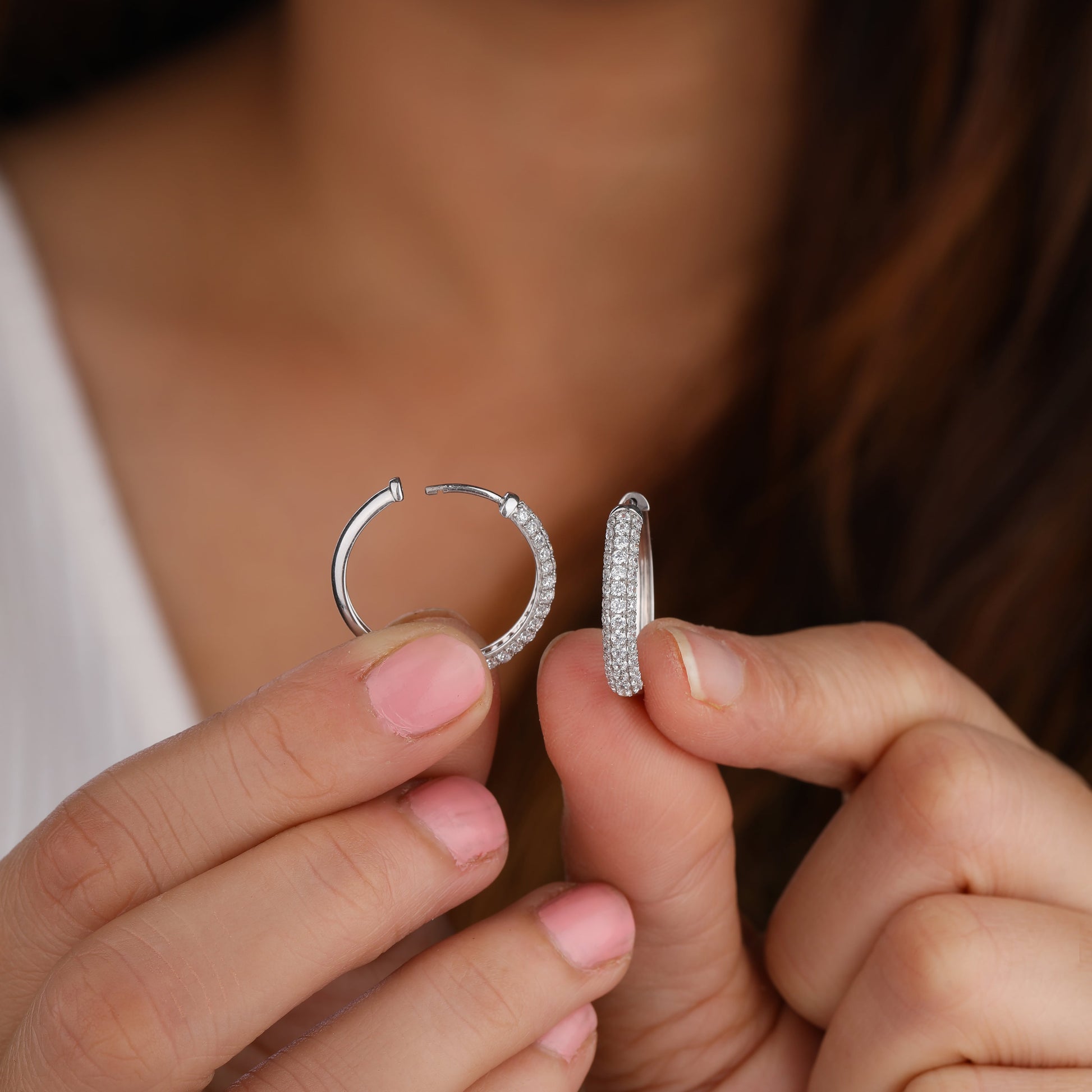 a person holding hoop earring