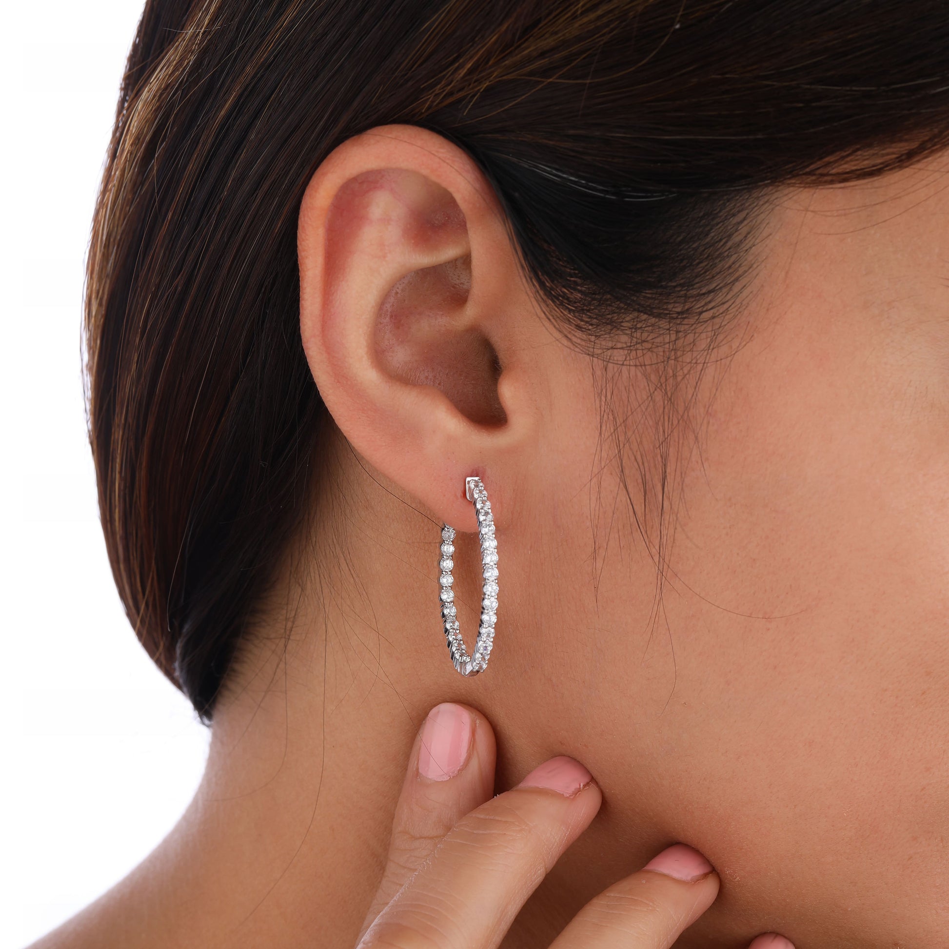 a person wearing a large inside out hoop earring